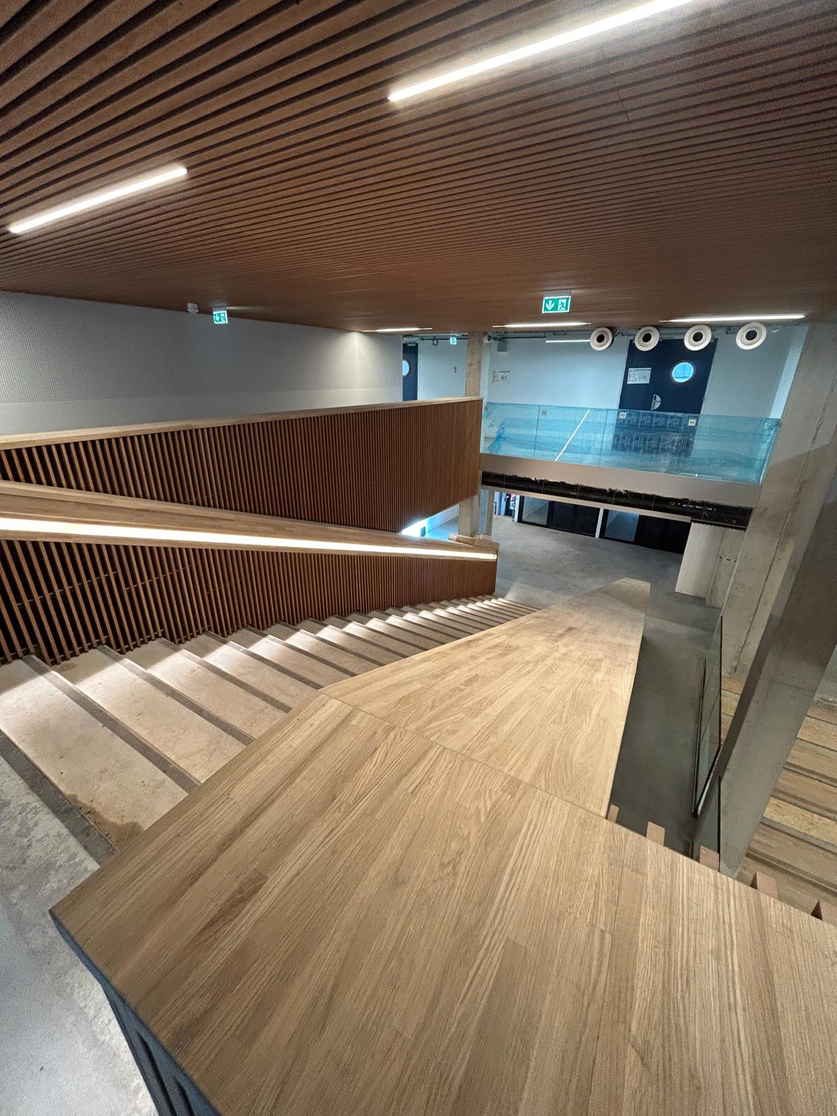 Le grand escalier et ses balustrades habillées bois.